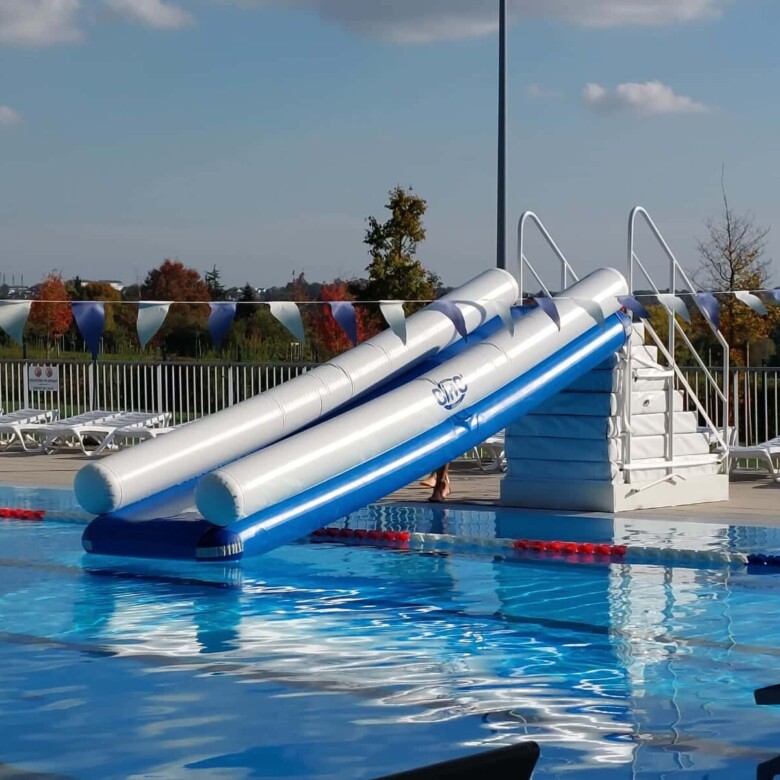 Photo d'un toboggan gonflable BimB'Gliss et son escalier aux marches antidérapantes, installé dans une piscine.