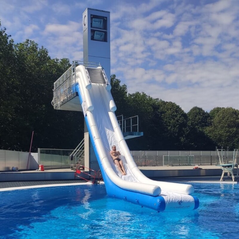 Photo du toboggan gonflable XL sur mesure attaché à un plongeoir de 5 mètres dans une piscine à Caen La Mer, dans le Calvados.